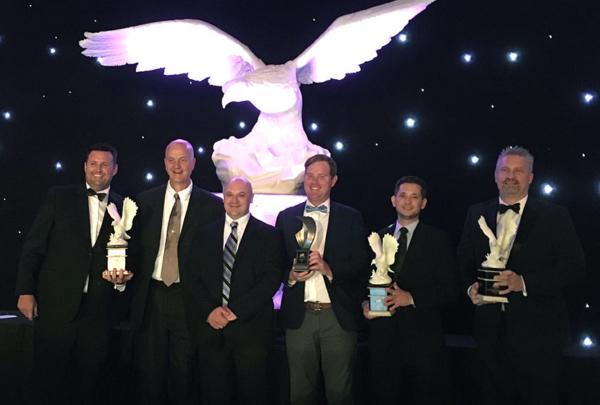 澳门足彩app team members pose with awards.